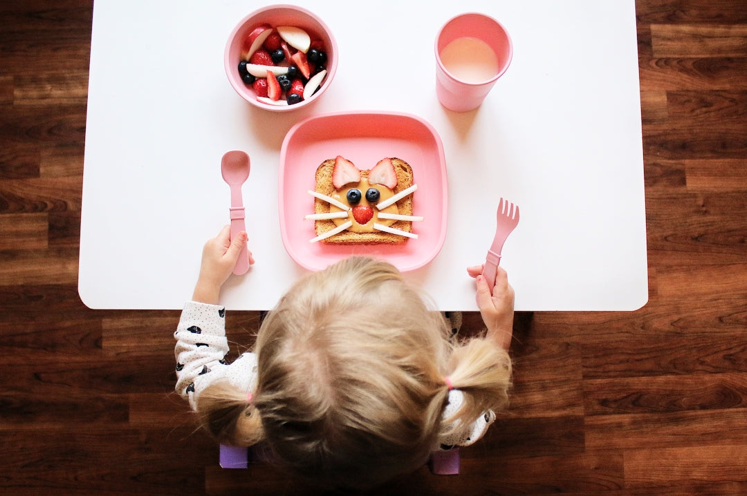 Kid eating breakfast with Re-Play cup, bowl and utensils