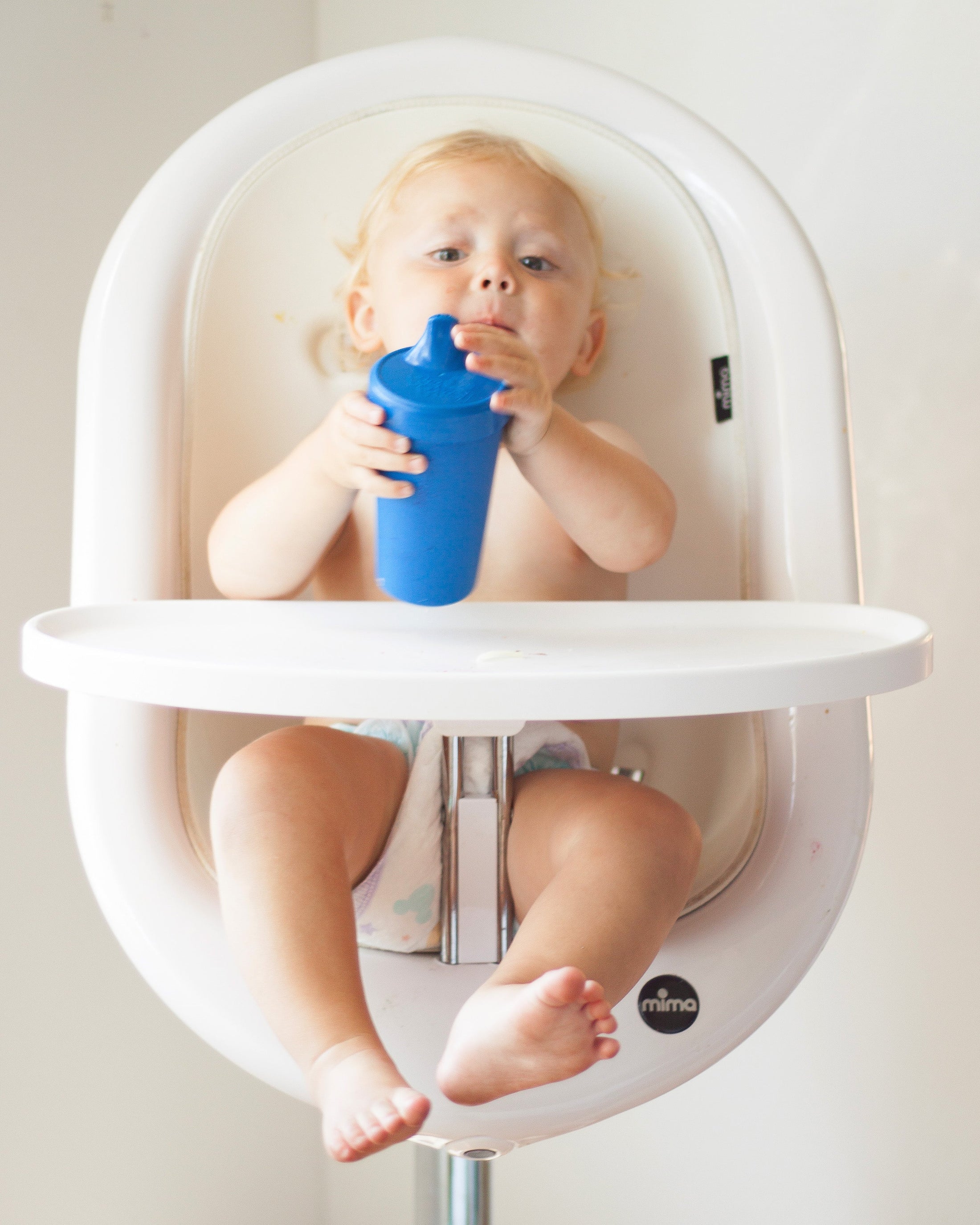 Baby drinking from navy blue Re-Play sippy cup