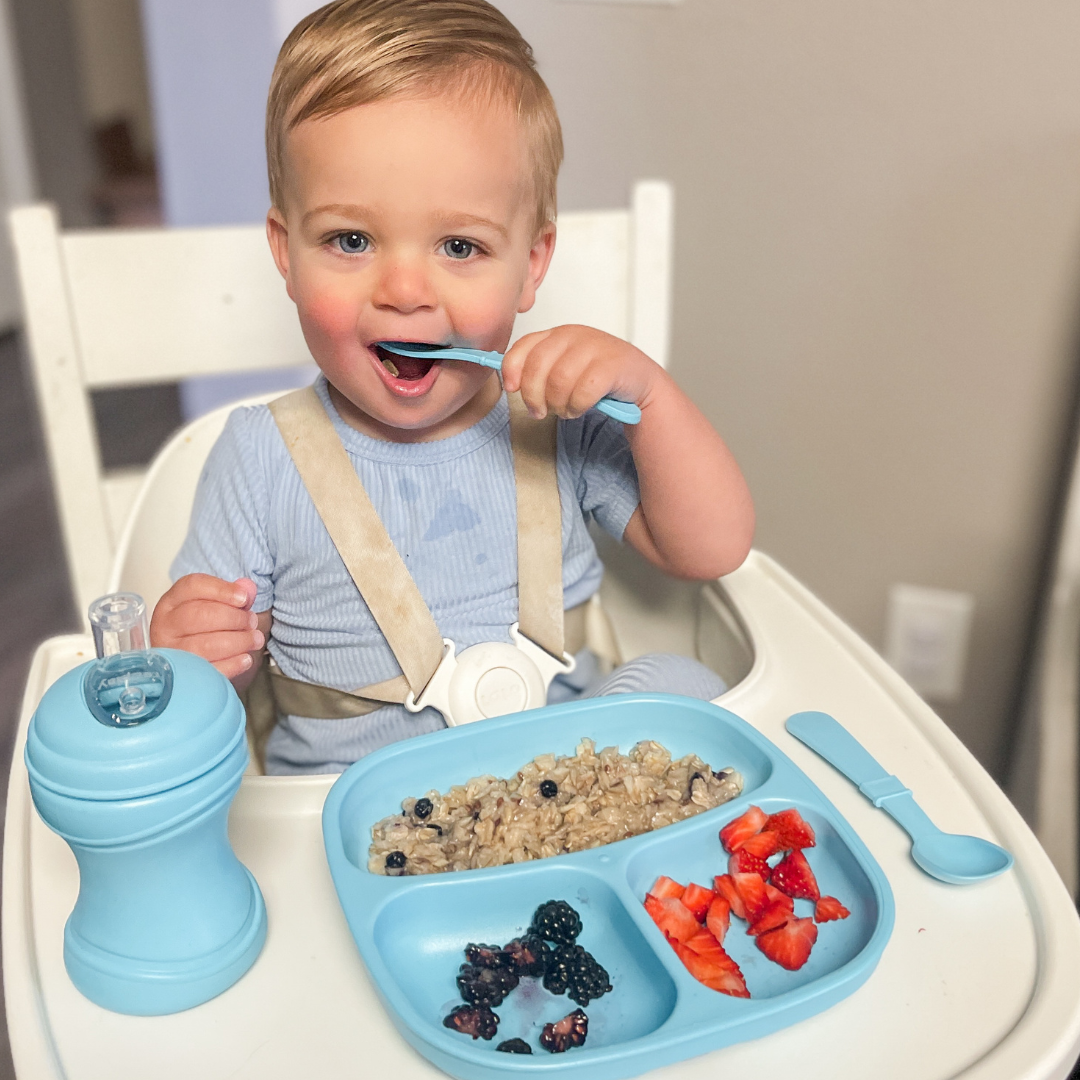 Toddler eating with Re-Play sippy cup, plate and utensils